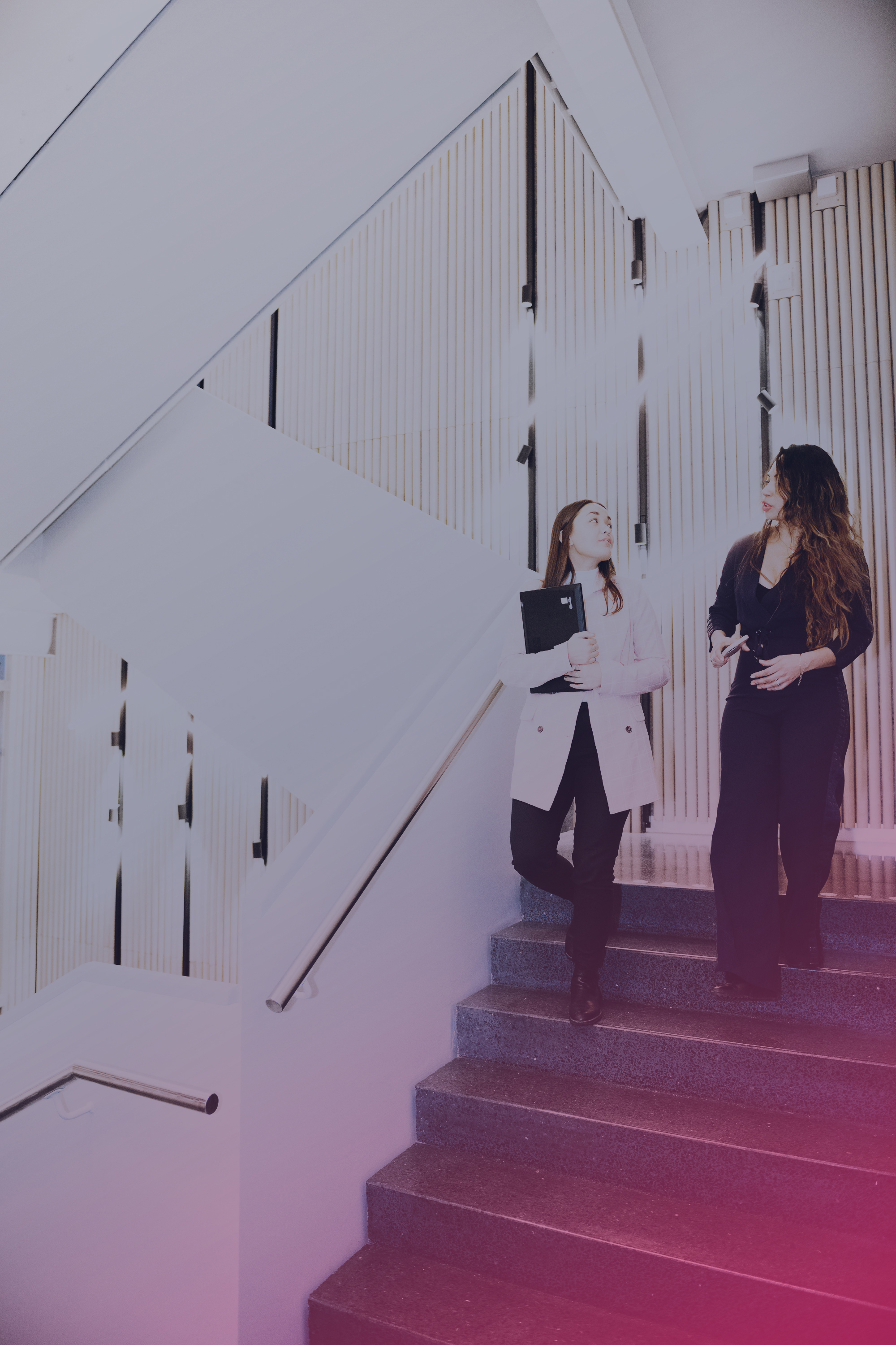 Two women arguing on their way down a flight of stairs. 