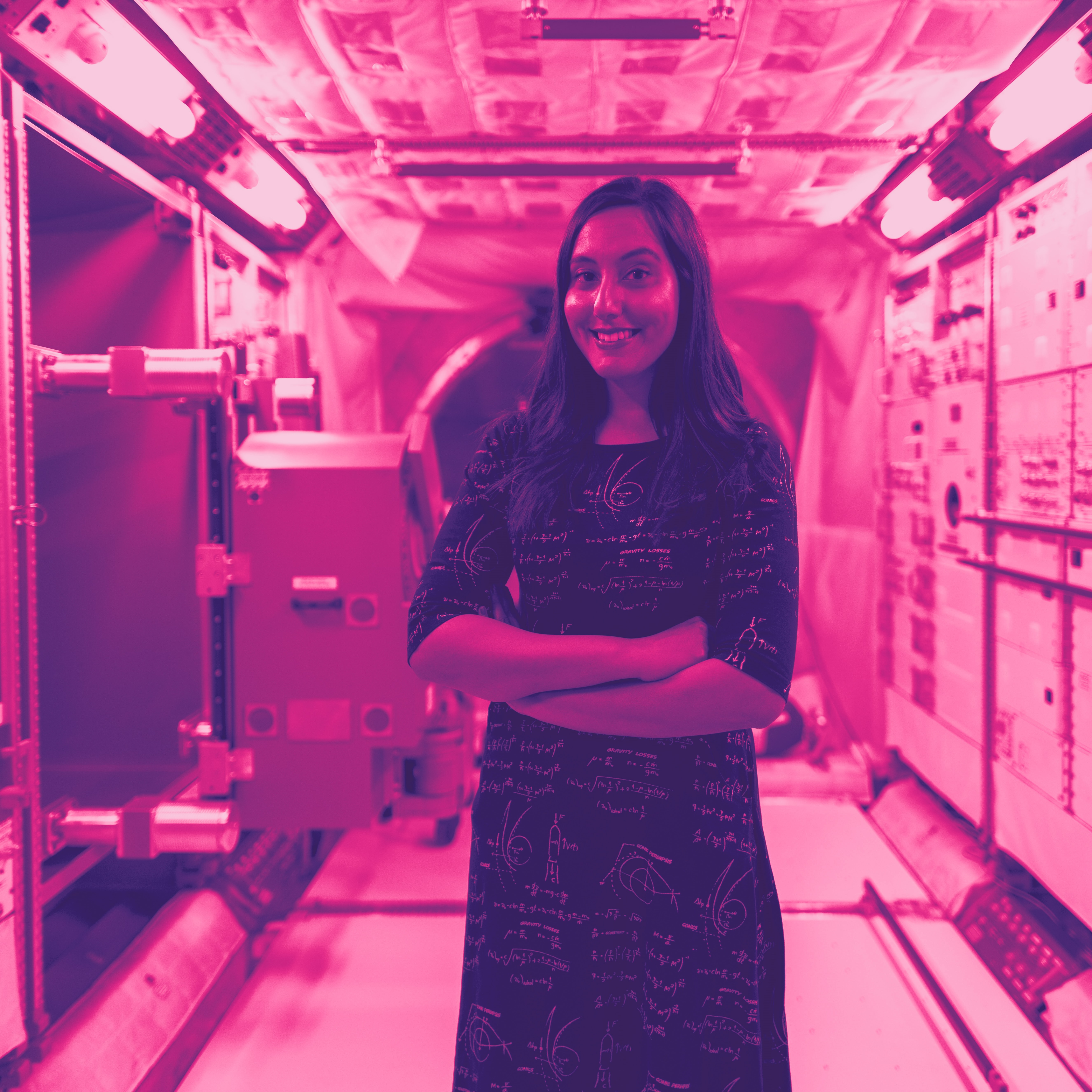 Woman standing in spaceship with arms crossed.