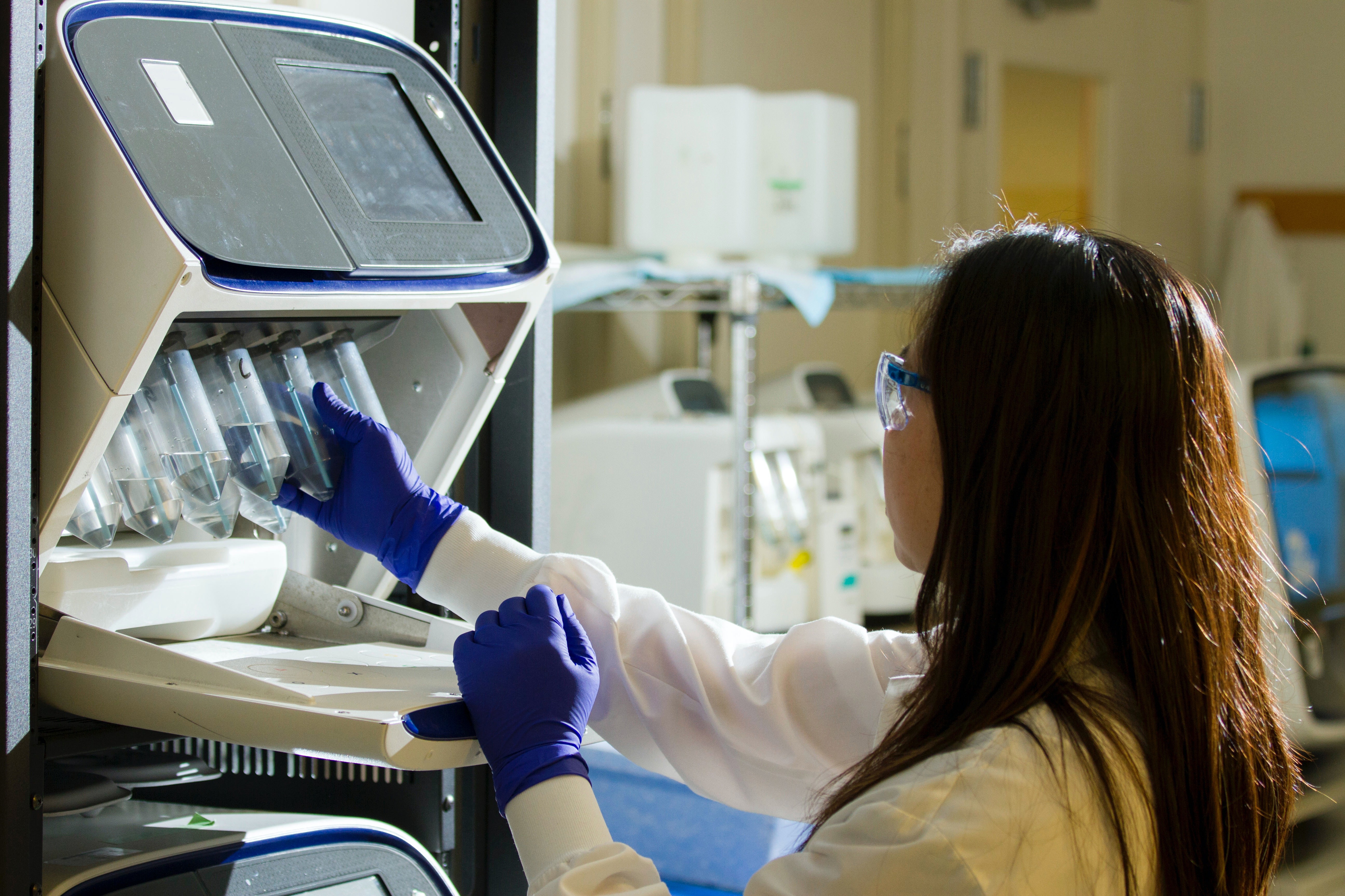 Young woman working with gloves in lab environment