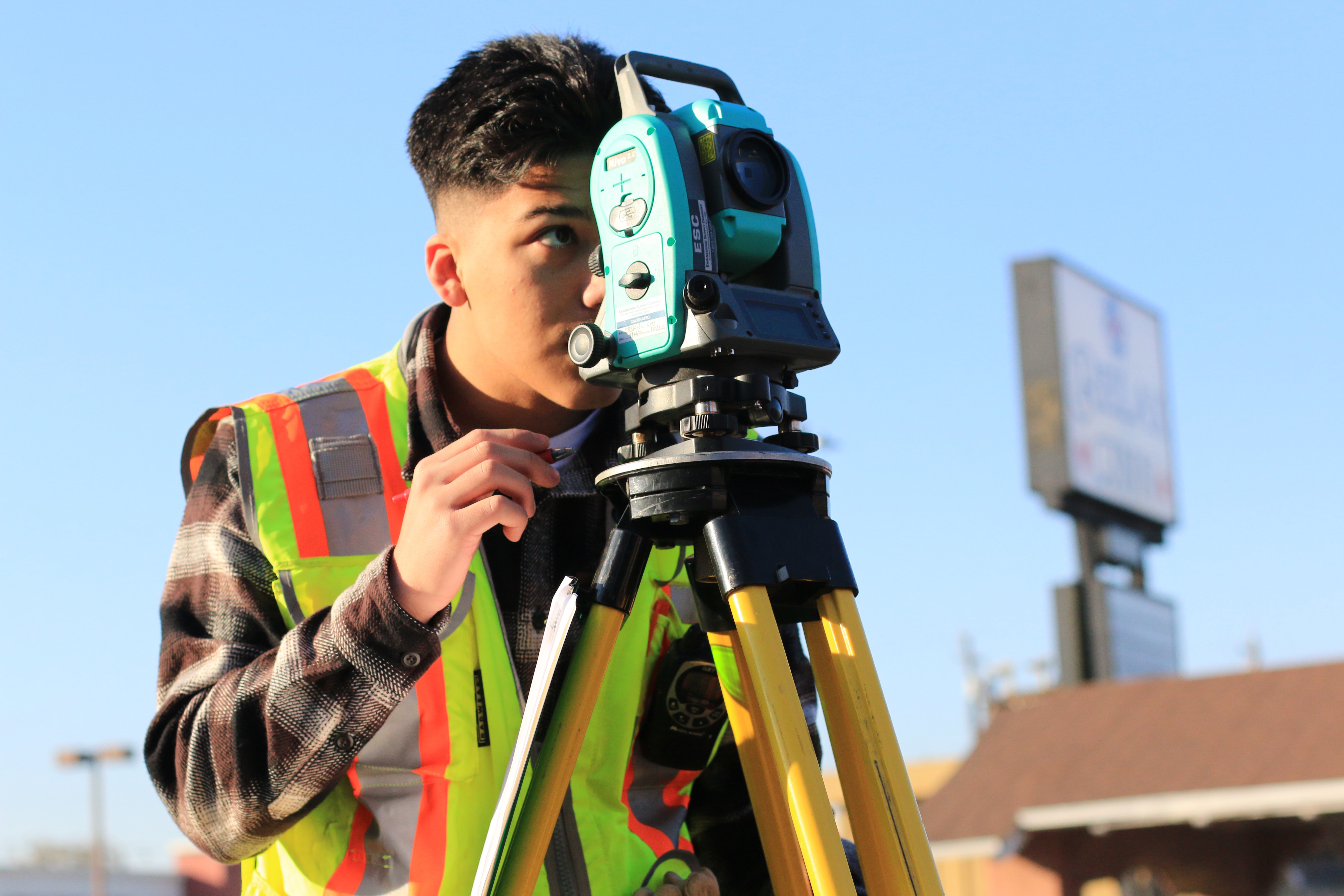 Person on construction site looking through laser meter